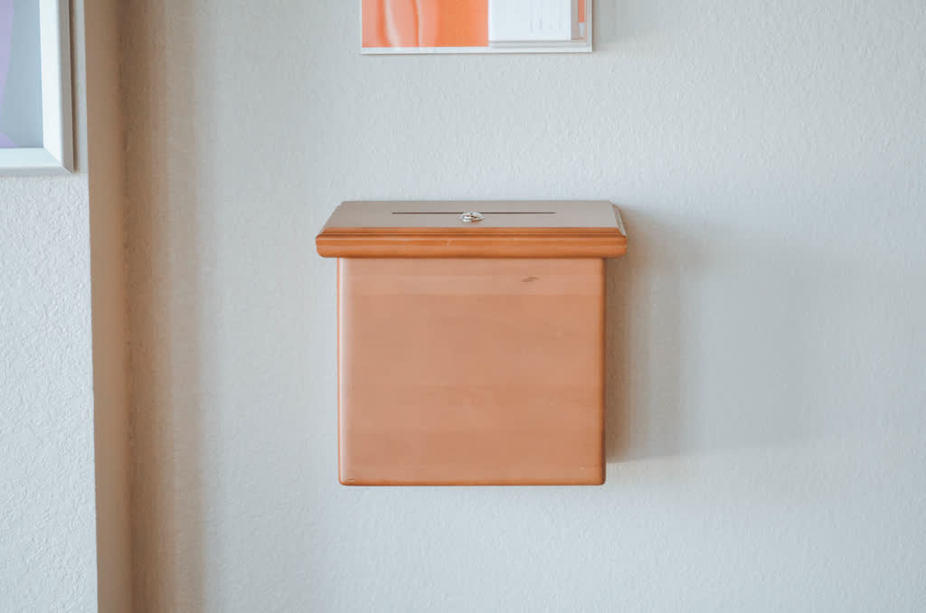 A wooden donation box on the wall of Immanuel Church